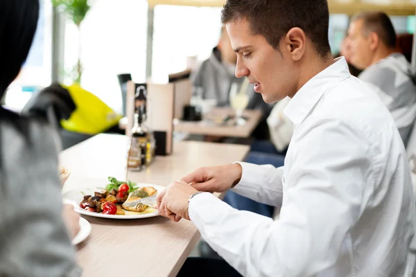 Ungt par njuta av lunch på en restaurang — Stockfoto