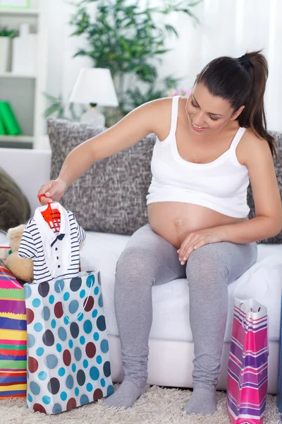 Femme enceinte faisant du shopping vêtements de bébé — Photo