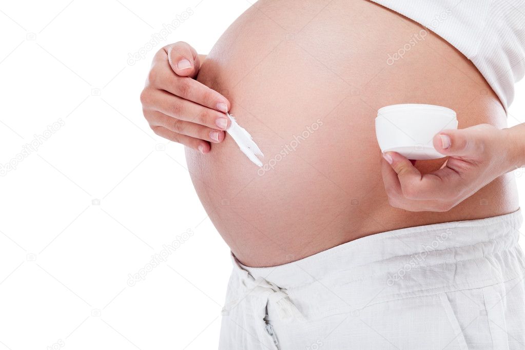 Pregnant woman putting cream on her belly