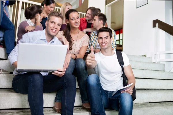 Студенты сидят на ступеньках в колледже — стоковое фото