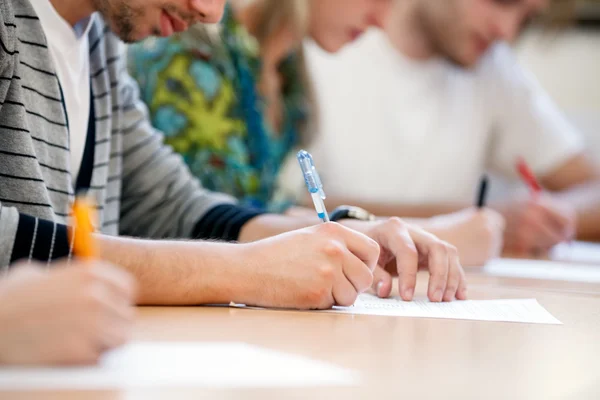 W ręce pismo studentów — Zdjęcie stockowe