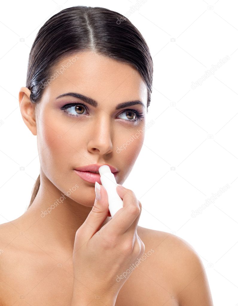 Woman applying balsam on lips
