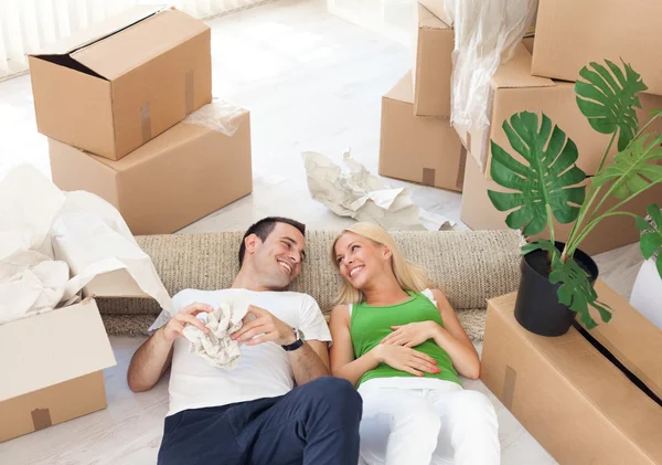 Couple relaxing in the middle of boxes — Stock Photo, Image