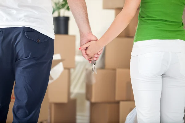 Par hålla händerna tillsammans i nya hem — Stockfoto