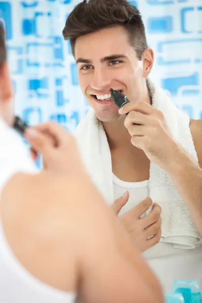 Man met trimmer in de buurt van zijn neus — Stockfoto