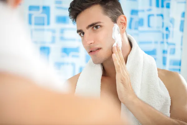 Hombre poniéndose crema de afeitar —  Fotos de Stock