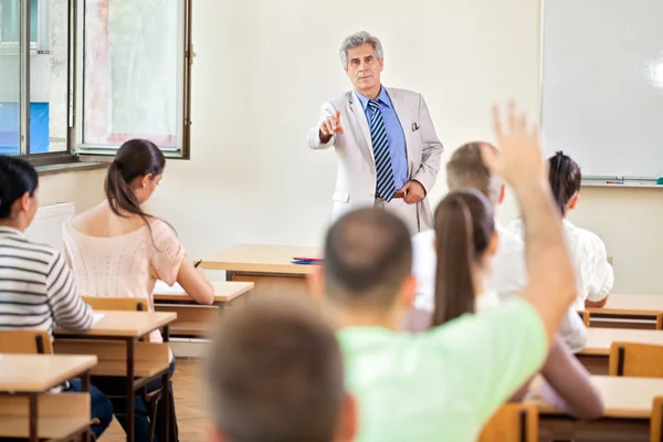 Student with hand up in class Royalty Free Stock Images