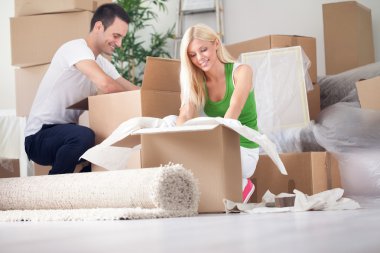 young couple unpacking or packing boxes clipart