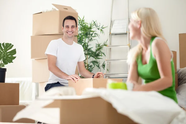 Aufgeregtes Paar im neuen Zuhause beim Auspacken von Kartons — Stockfoto