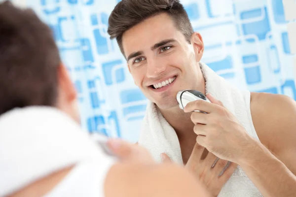Gülümseyen adam Elektrikli tıraş makinesi kullanma — Stok fotoğraf
