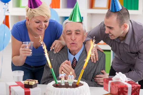 Senior man blowing candles — Stock Photo, Image