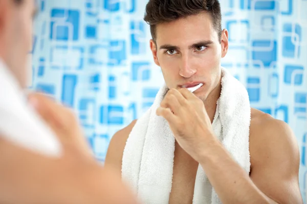 Man brushing teeth in front of mirror — Stock Photo, Image