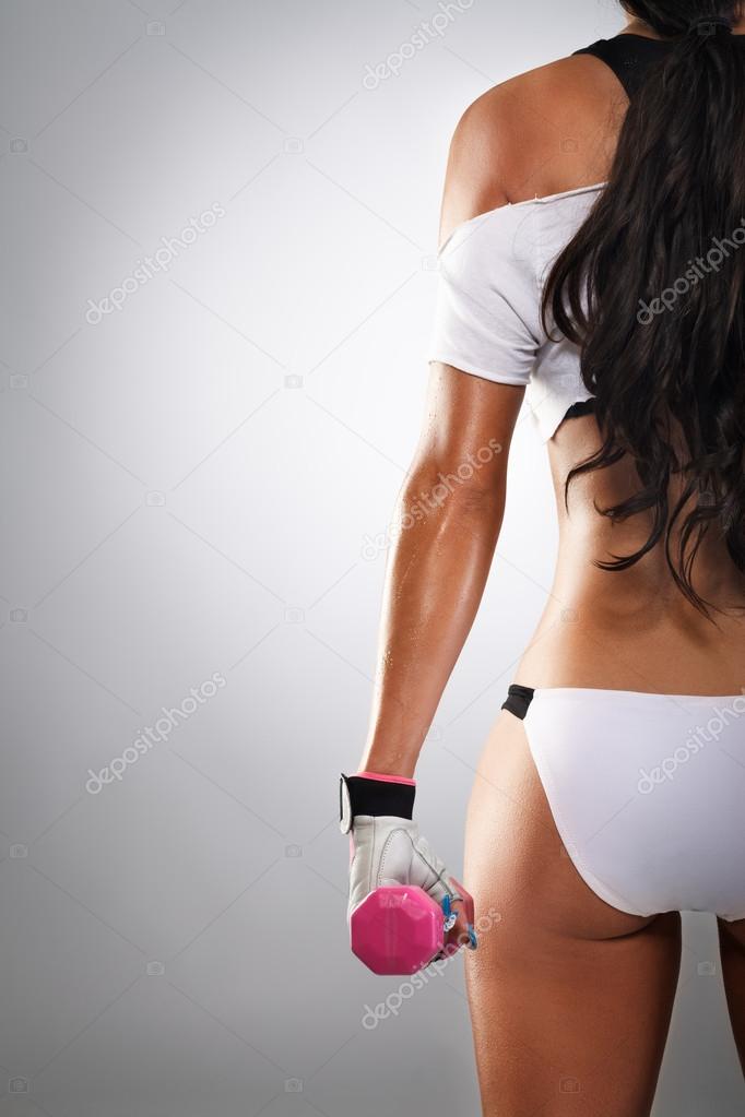 woman body from back holding dumbbells