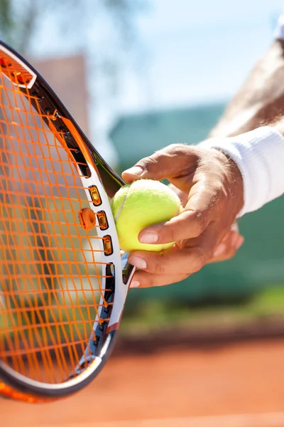 Hand met tennisbal en racket — Stockfoto