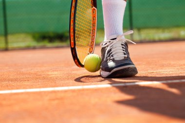 Top ve tenis raketi ile bacak