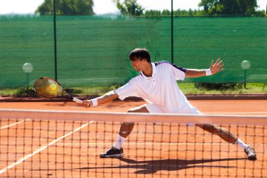 Genç adam tenis oynuyor.