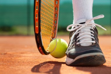 Tenis raket ve top yakın sporcu bacaklar