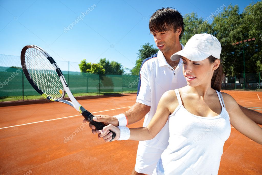 Woman and male tennis instructor practicing
