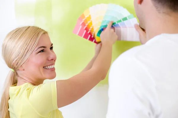 Casal feliz escolhendo cores para pintura — Fotografia de Stock