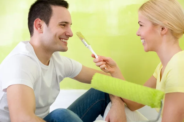 Casal se divertindo enquanto pinta uma sala — Fotografia de Stock