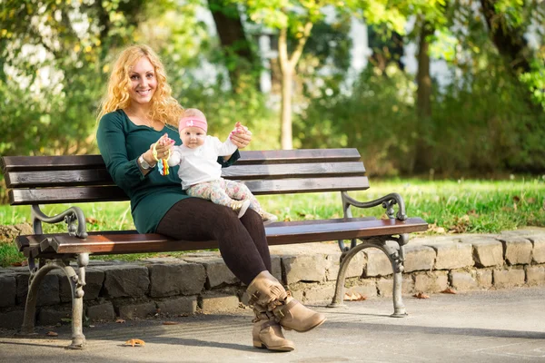 Mom with baby on a park bench — Stock Photo, Image