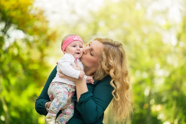 Mutter küsst ihre Tochter Baby — Stockfoto