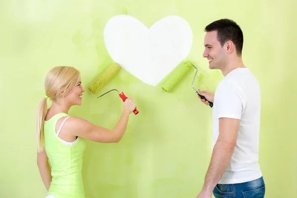 Couple painting heart on wall — Stock Photo, Image