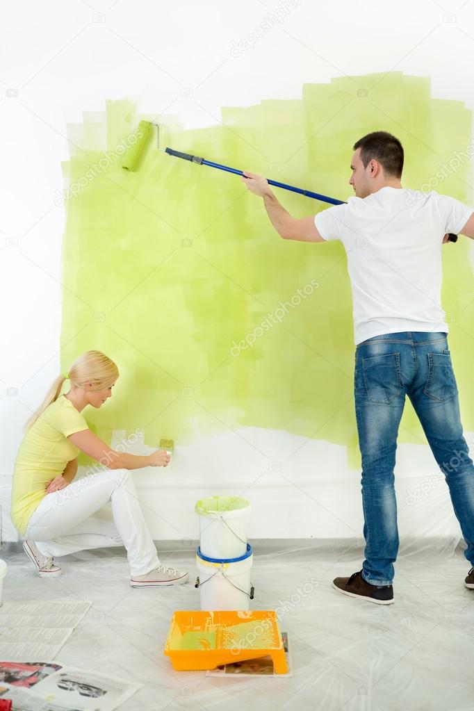 Couple together painting wall