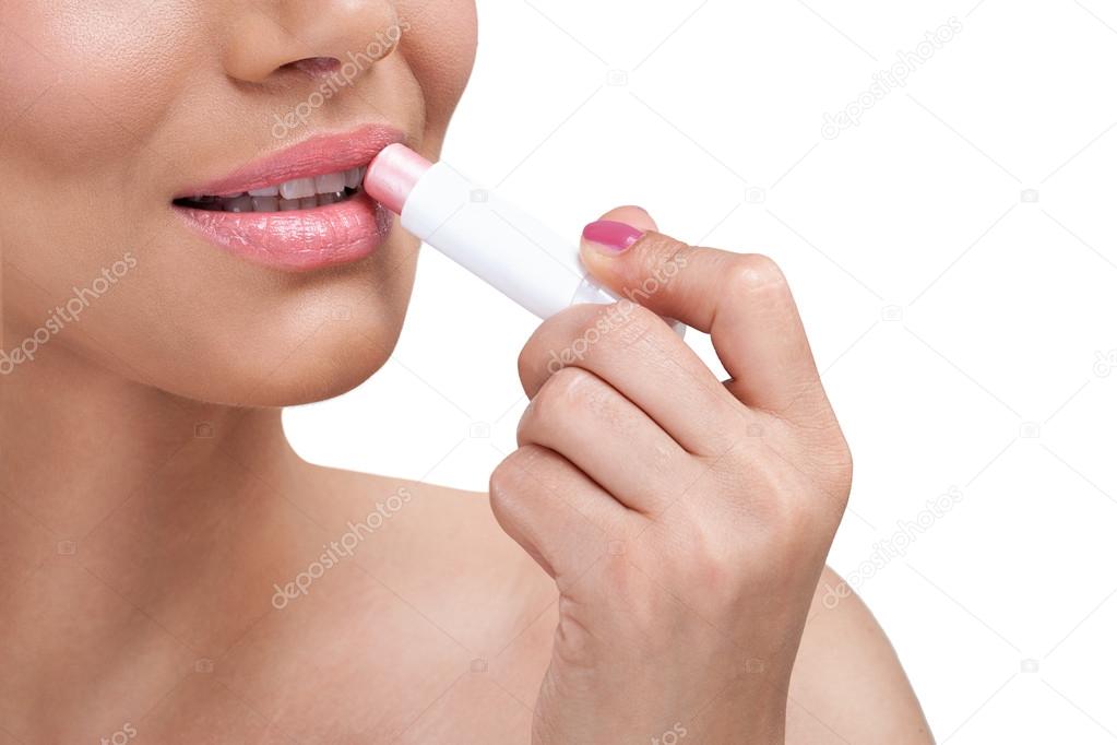Beautiful woman  applying balsam for lips