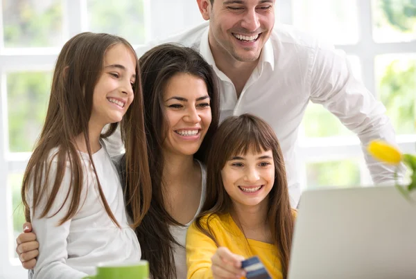 Familia feliz mirando el ordenador portátil — Foto de Stock