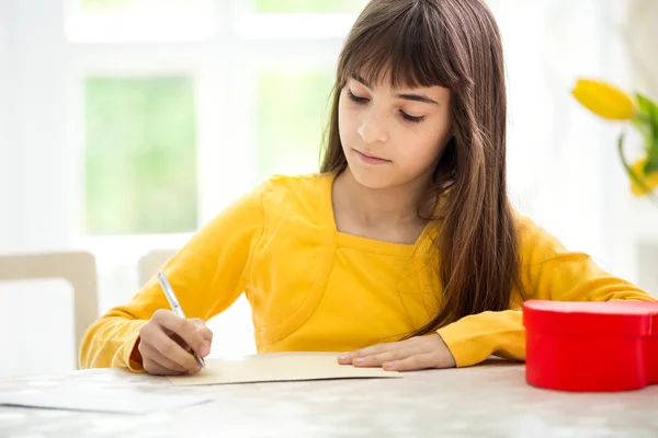 Schattig meisje schrijven wenskaart — Stockfoto