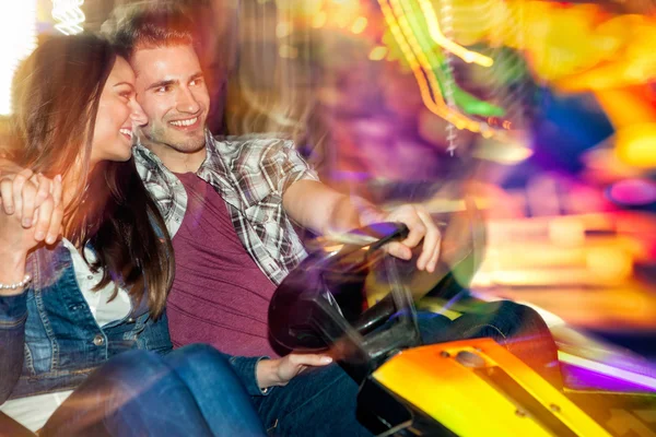 Молодая пара влюбленных в бампер автомобиль dodgem езды — стоковое фото