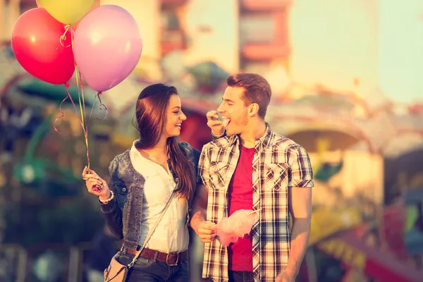 Love couple in amusement park with cotton candy — Stock Photo, Image
