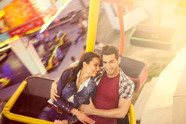 Joven pareja teniendo un paseo en una noria — Foto de Stock