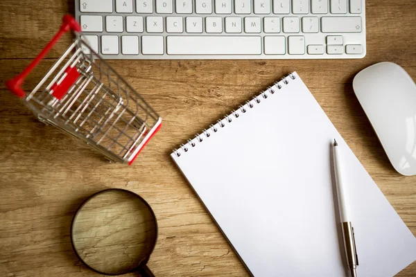 Online shopping  - Wooden desk above with little shopping chart — Stock Photo, Image