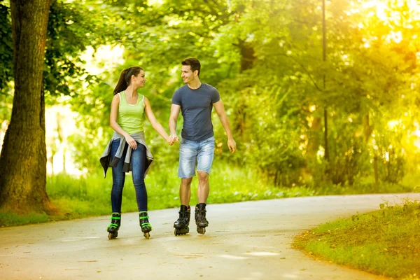 Lovers in nature on rollerblades — Stock Photo, Image