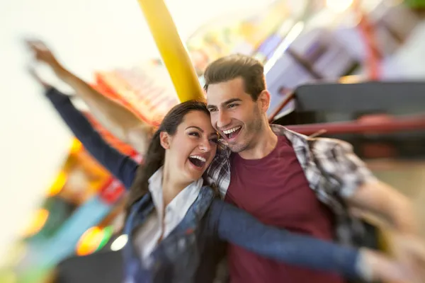 Laughing couple enjoy in riding ferris wheel — Stock Photo, Image