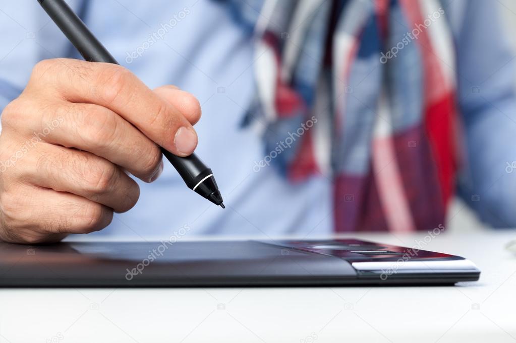 Hand with pen  and graphics tablet