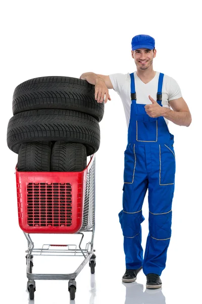 Mecánico con neumáticos dando un pulgar hacia arriba — Foto de Stock