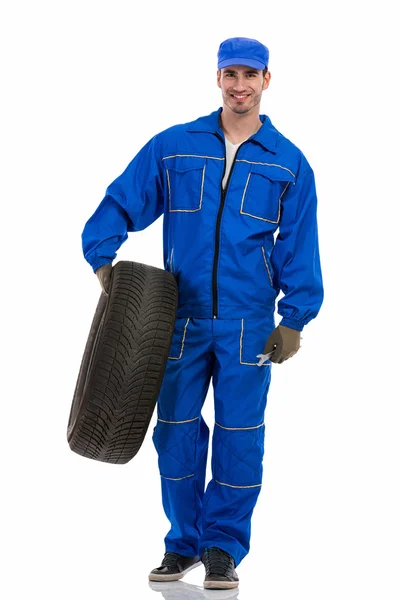 Young mechanic holding tire — Stock Photo, Image