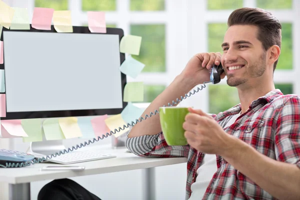 Uomo sorridente che beve caffè in ufficio — Foto Stock