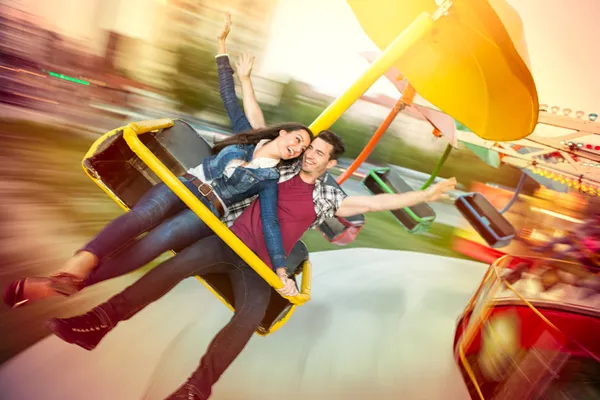 Joven pareja feliz divirtiéndose en el parque de atracciones —  Fotos de Stock