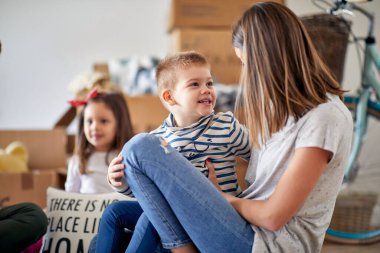 Yeni bir yere taşınan iki çocuklu mutlu beyaz bir aile.