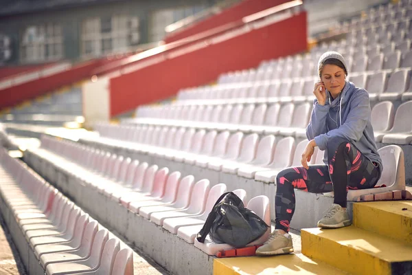 Молодая Задумчивая Женщина Сидит Трибуне Стадионе Готовится Тренировке Прекрасный Солнечный — стоковое фото