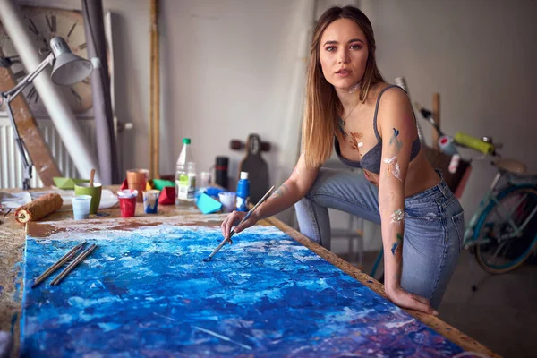 Çok Ateşli Seksi Genç Bir Kadın Sanatçı Masanın Üzerinde Duruyor — Stok fotoğraf