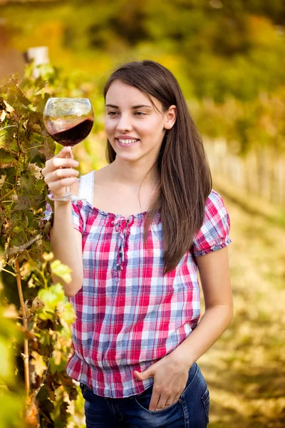 Жінка з келихом вина в винограднику . — стокове фото
