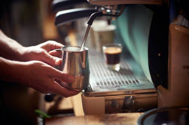 Kokulu espresso içeceği yapmak için barmen tarafından espresso aparatında kaynatılan bir süt. Kahve, içecek, bar.
