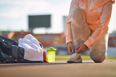 Stadyumda güzel bir günde atletizm eğitimine hazırlanan genç bir kadın. Spor, atletizm, sporcular