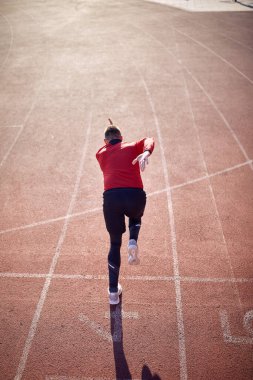 Profesyonel erkek koşucu stadyumda antrenman yapıyor.