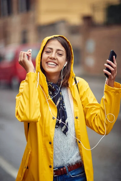 Smiling Woman Yellow Raincoat Listens Music Rain — Stock Photo, Image